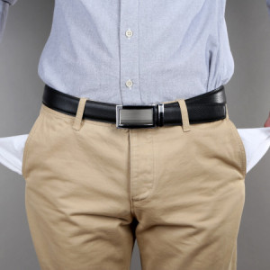 Man showing his empty pockets on grey background